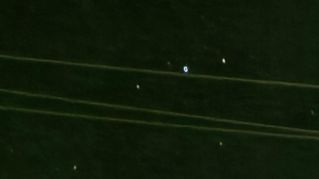 Artist concept of cold glowing orbs reacting near a military aircraft over ocean at night