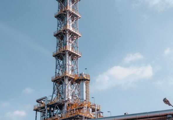 Oil refinery towers against blue sky